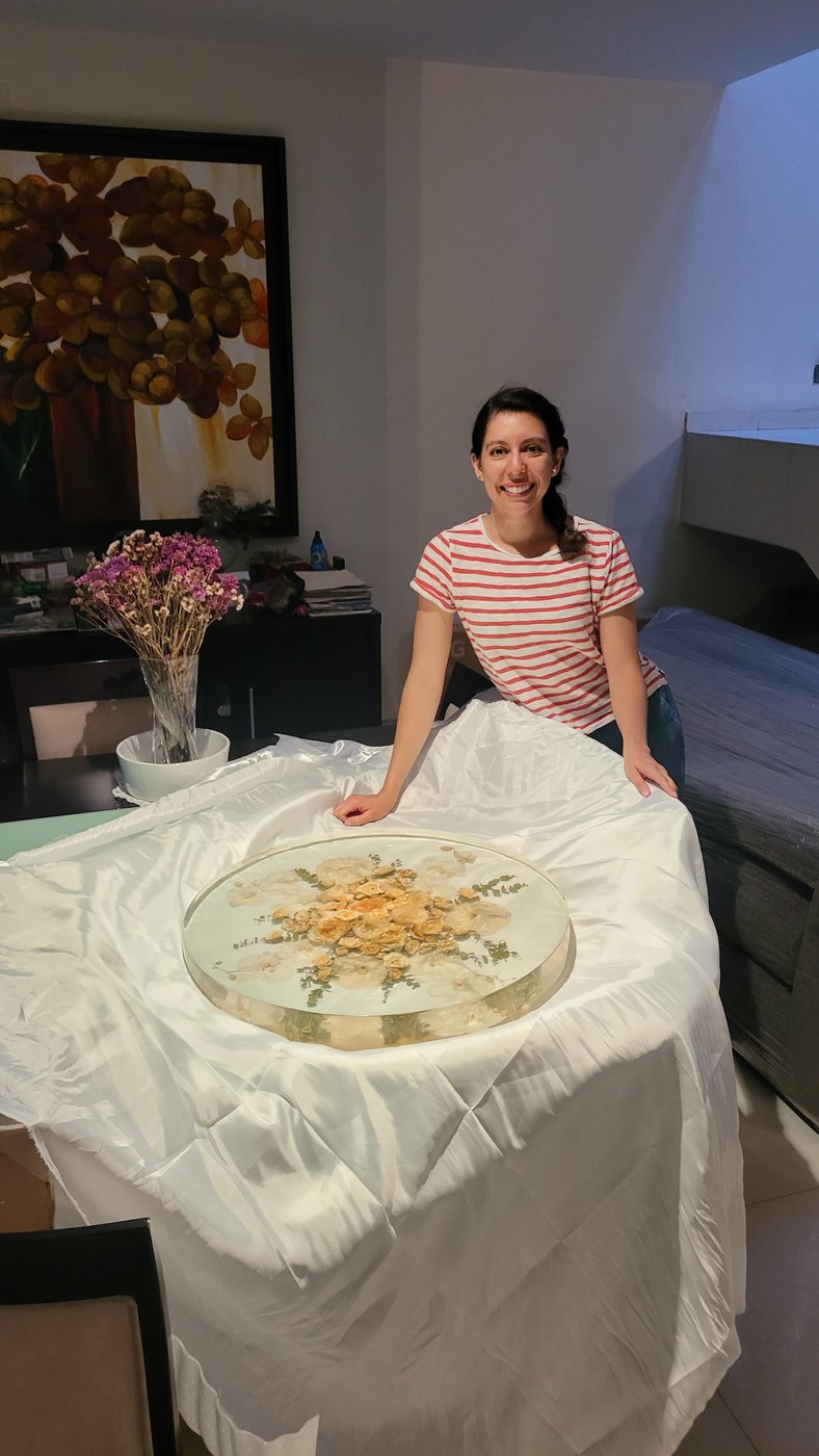 The client with her finished resin bouquet plaque on a cloth-draped table